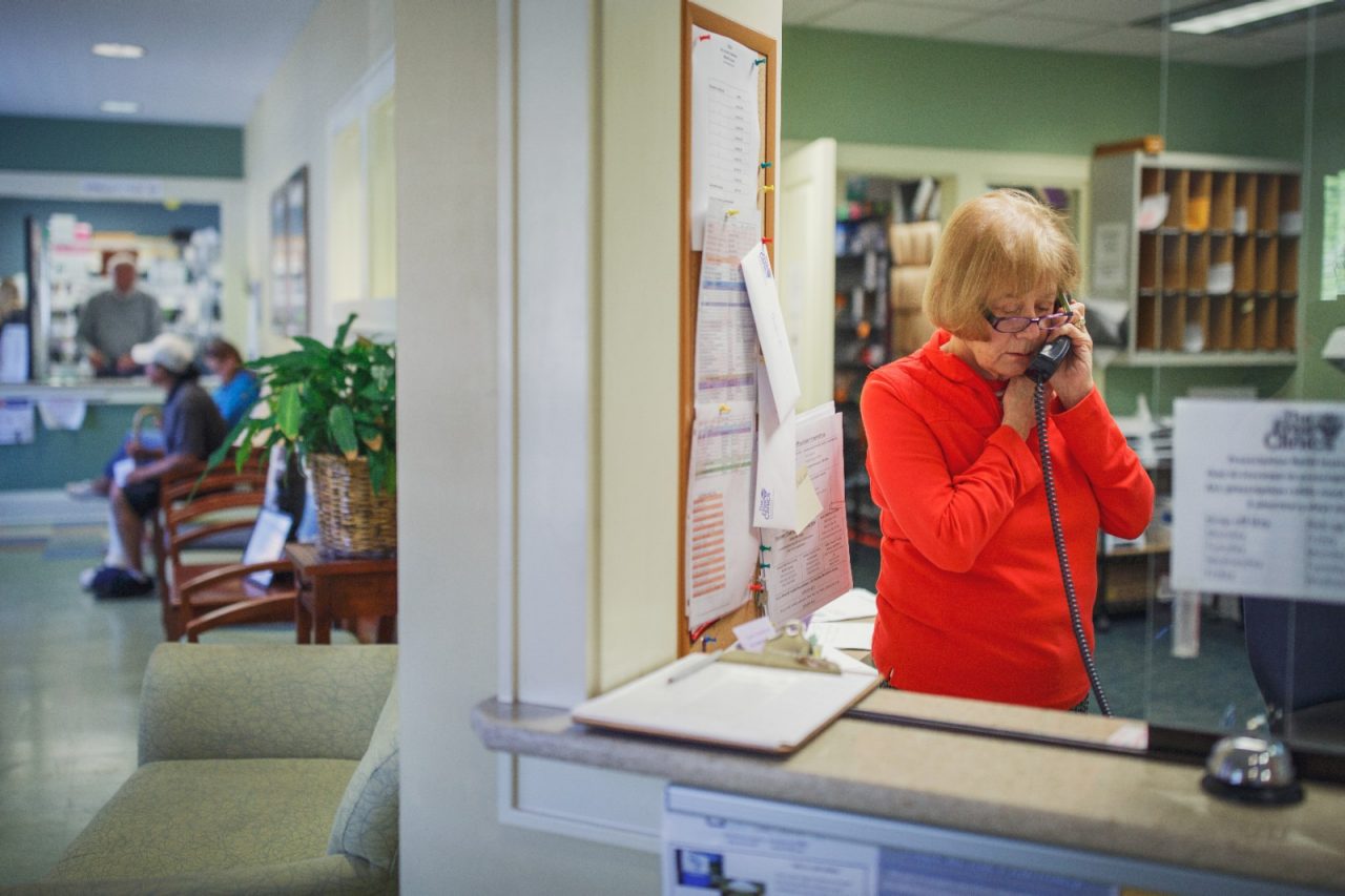 A receptionist answers the phone at a free clinic.