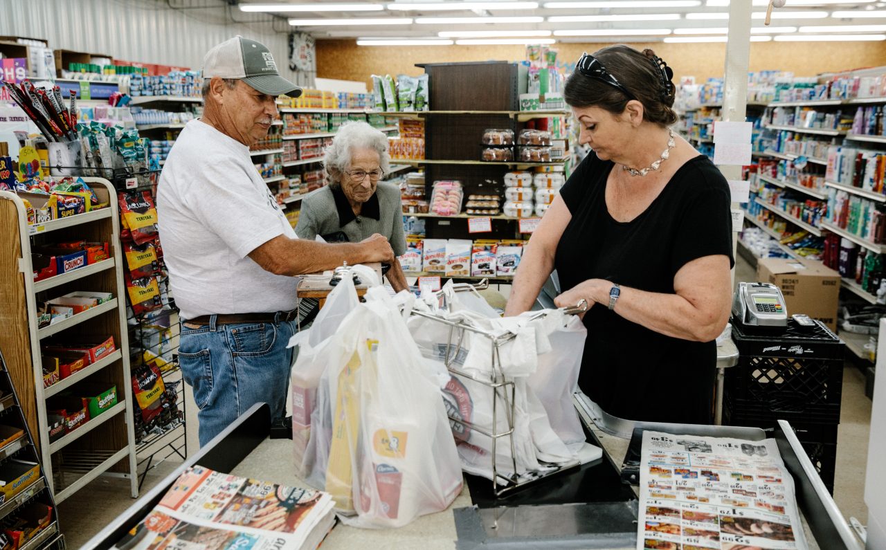 A man helping his mother with her food shopping. 