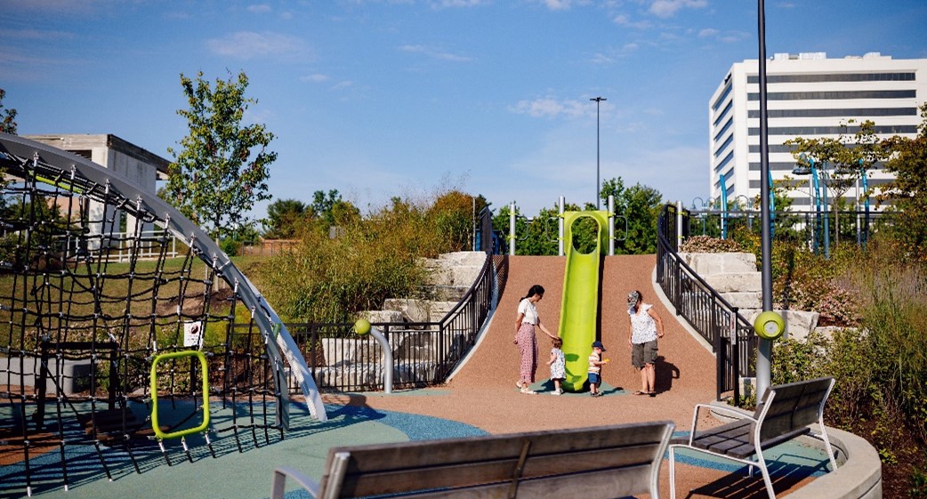 A family plays near a slide at a playground.