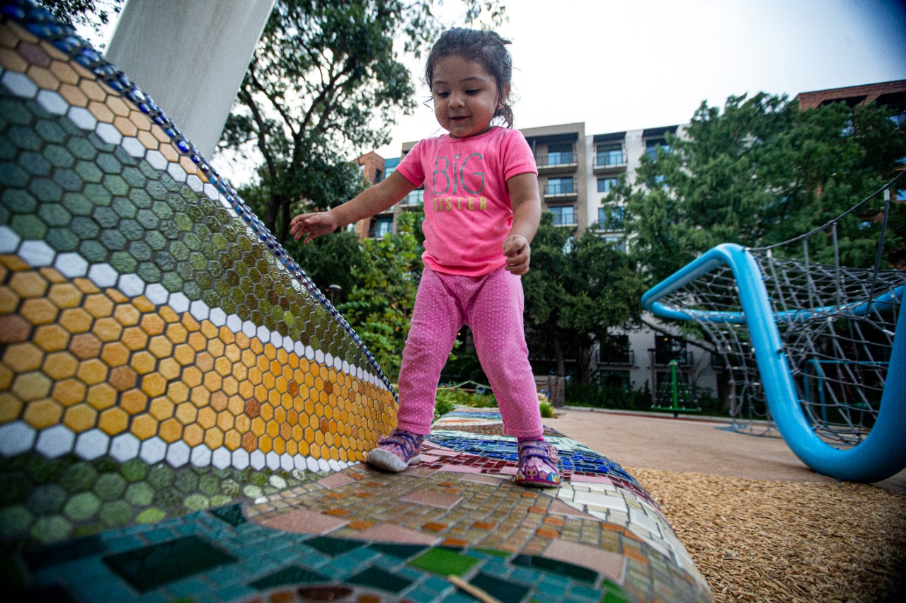 A toddler playing in a playground.